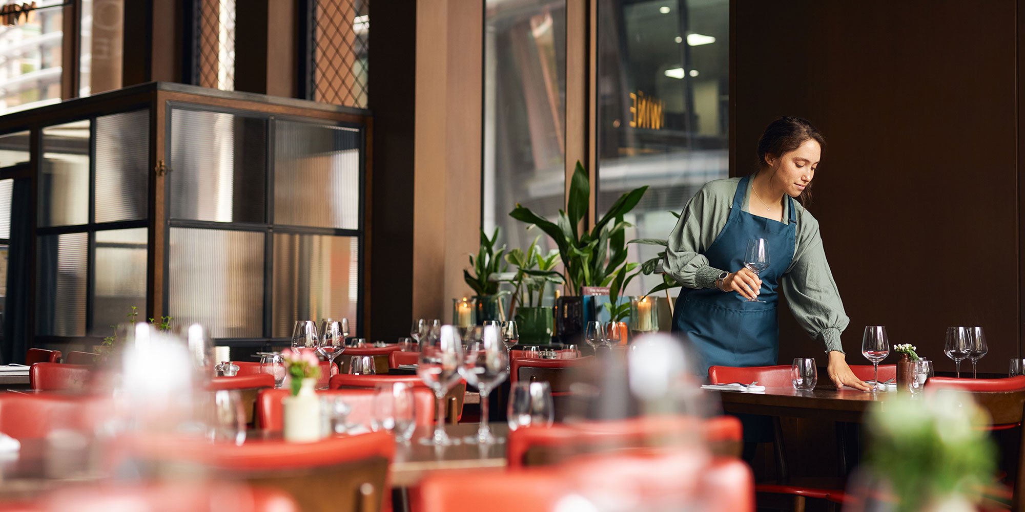 Head waitress setting wine glasses on tables