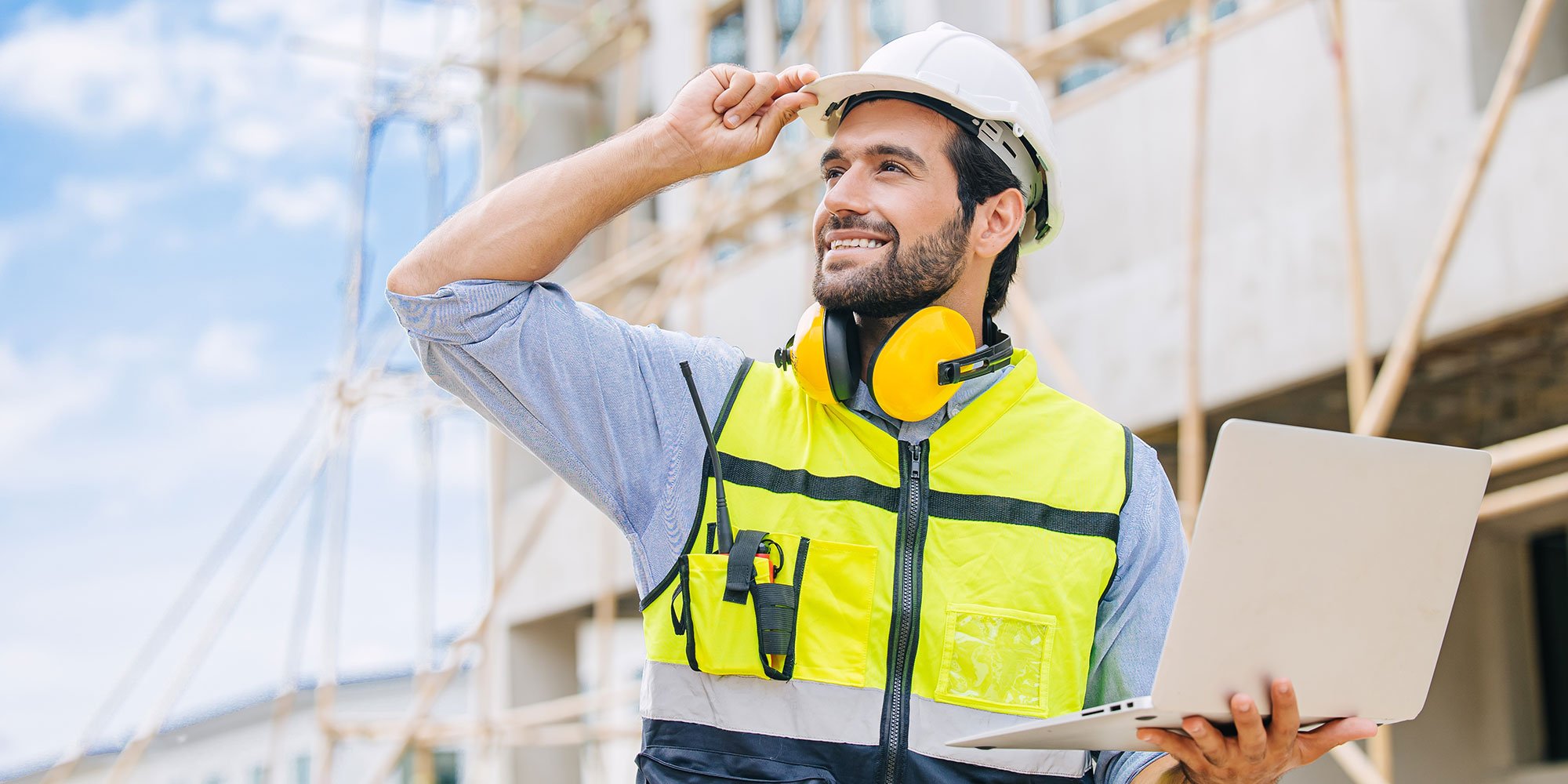 construction worker on laptop overseeing a project