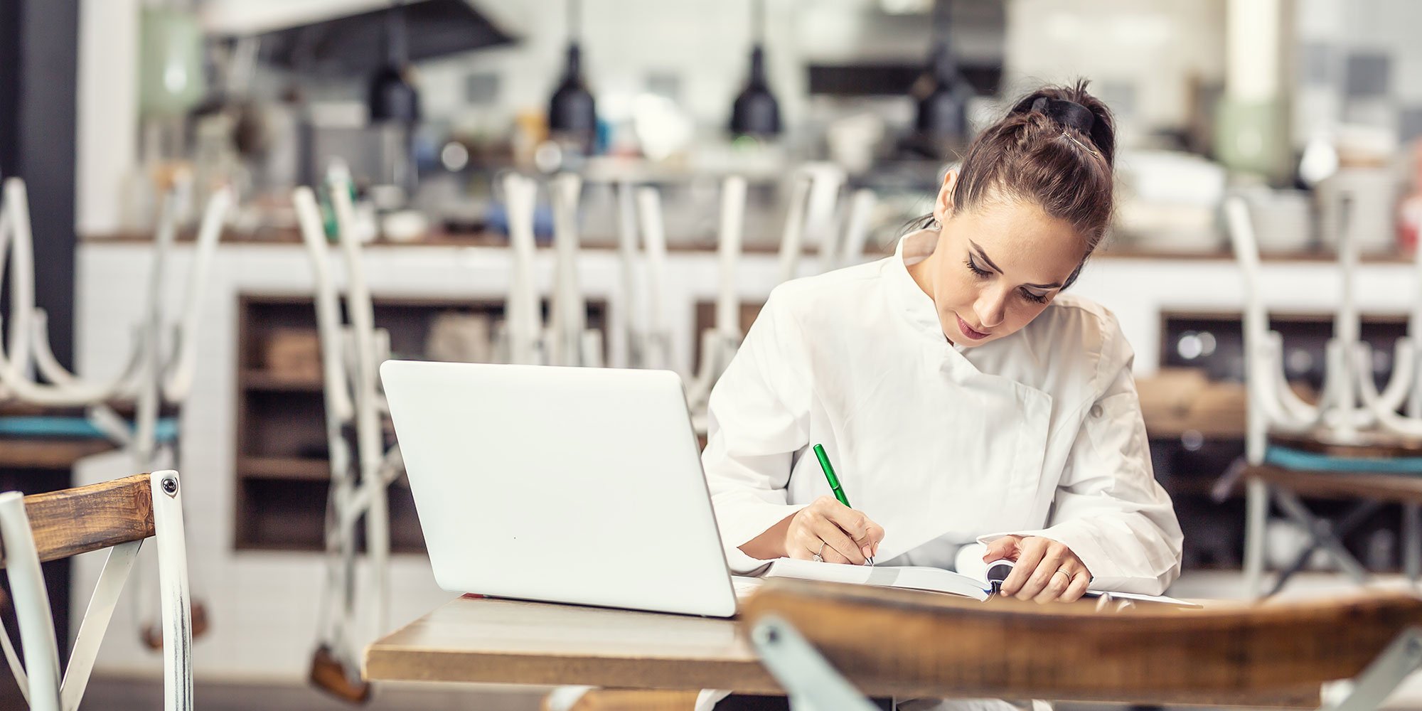 Restaurant manager taking notes on social media strategy